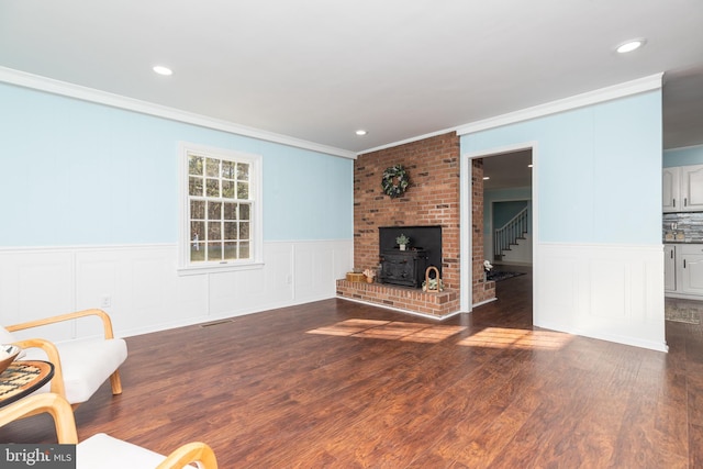 living room with dark hardwood / wood-style flooring, a wood stove, and crown molding