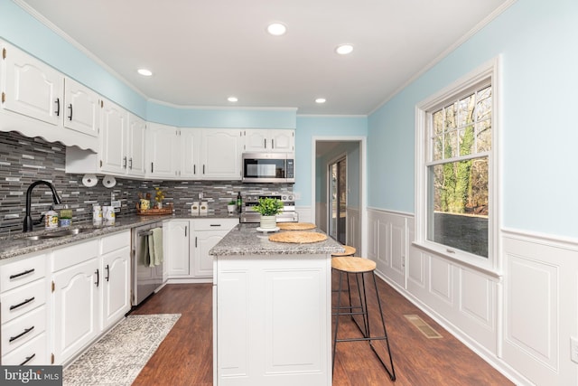 kitchen with white cabinets, a kitchen island, and appliances with stainless steel finishes