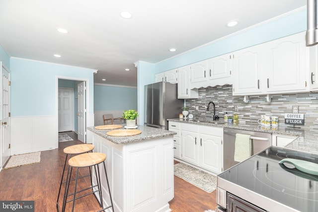 kitchen featuring dark hardwood / wood-style floors, a center island, white cabinetry, and appliances with stainless steel finishes