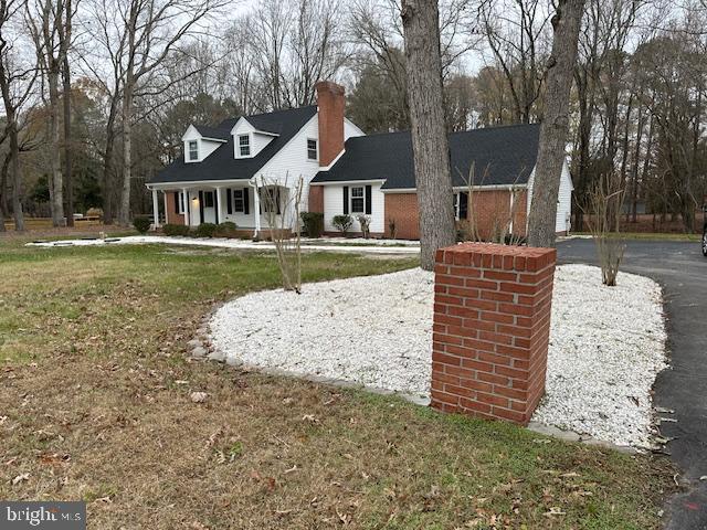 cape cod house with a front lawn