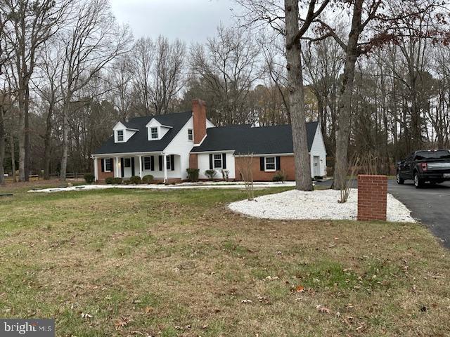 cape cod home with a front yard