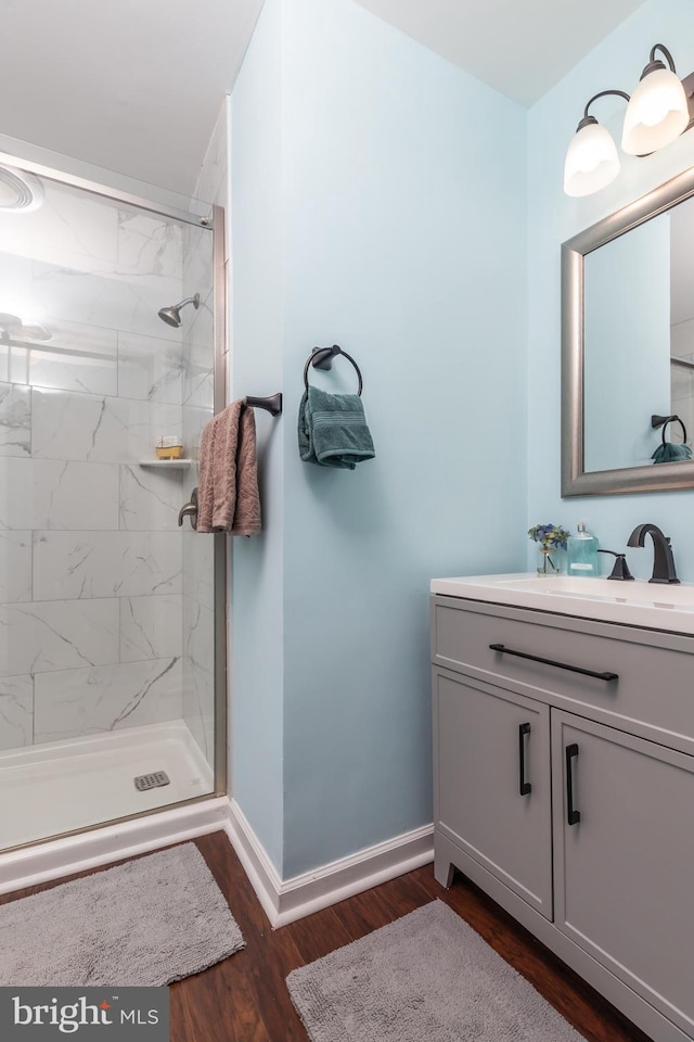 bathroom with vanity, wood-type flooring, and tiled shower