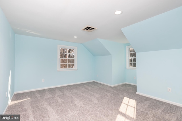 additional living space featuring light carpet and lofted ceiling