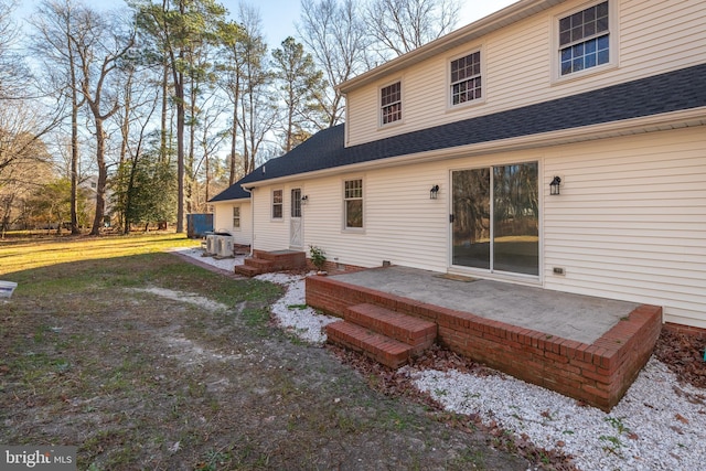 back of property featuring a lawn, central AC, and a patio