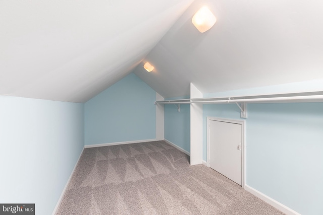 spacious closet featuring light colored carpet and vaulted ceiling