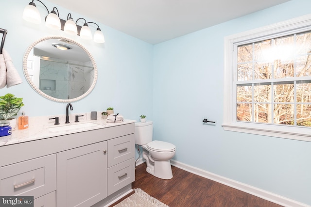 bathroom with hardwood / wood-style flooring, vanity, toilet, and walk in shower