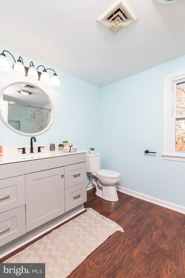 bathroom with vanity, toilet, wood-type flooring, and walk in shower