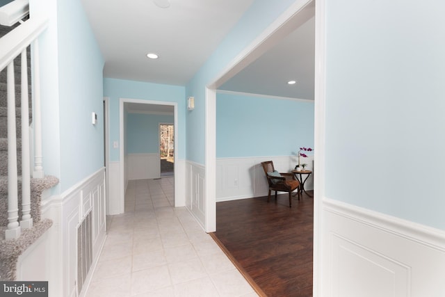 hall featuring light hardwood / wood-style flooring and crown molding