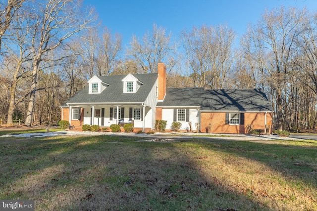 cape cod-style house featuring covered porch and a front yard