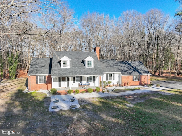 cape cod home with a porch and a front yard