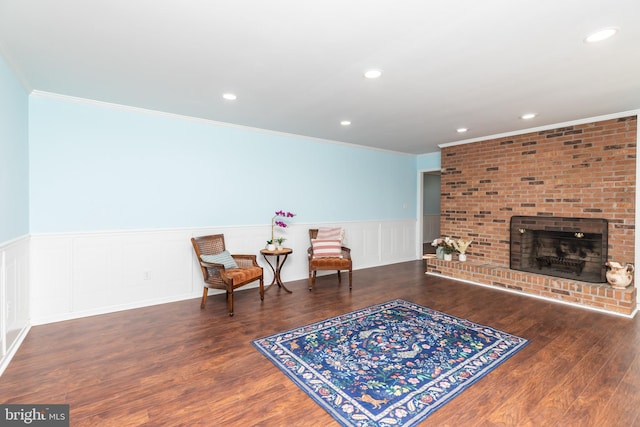 sitting room with a fireplace, dark hardwood / wood-style flooring, and crown molding