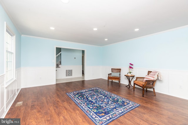 living area featuring hardwood / wood-style flooring and ornamental molding