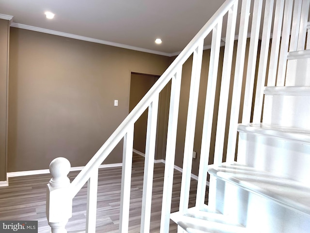 stairway with hardwood / wood-style floors and ornamental molding