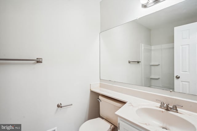 bathroom with vanity, toilet, and walk in shower