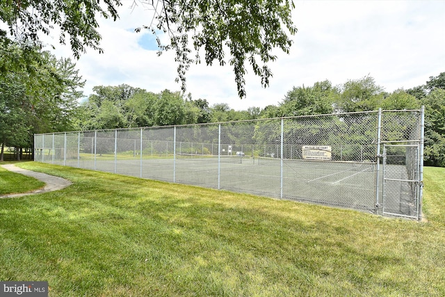 view of tennis court featuring a lawn