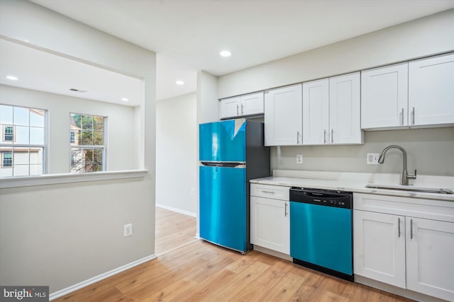 kitchen with white cabinetry, sink, stainless steel appliances, and light hardwood / wood-style floors