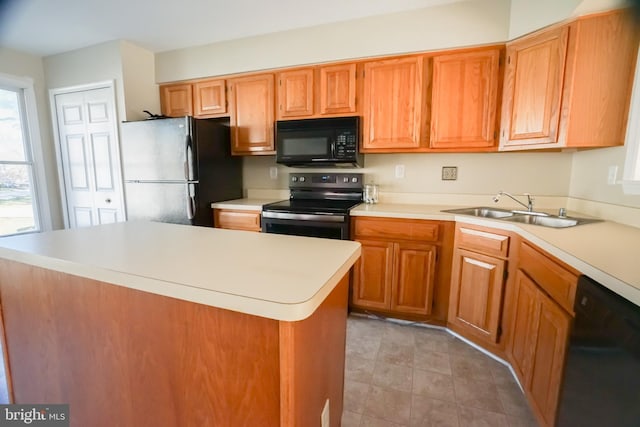 kitchen with sink, a center island, and black appliances