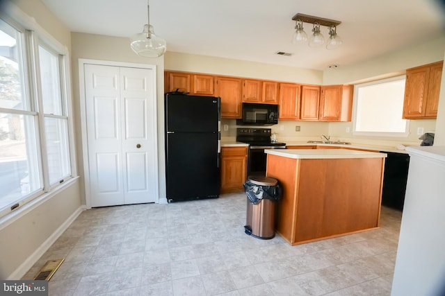 kitchen featuring hanging light fixtures, sink, a wealth of natural light, and black appliances