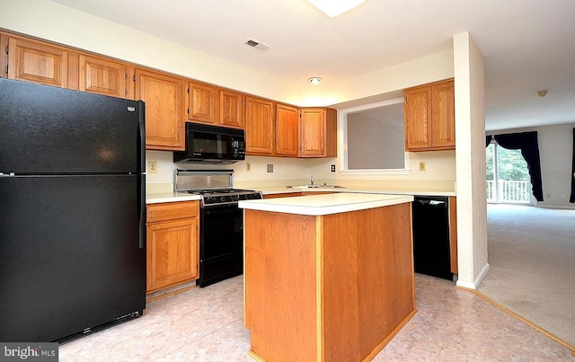 kitchen with a center island, black appliances, and sink