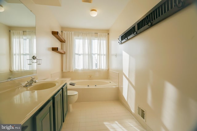 bathroom featuring tile patterned floors, vanity, toilet, and tiled tub