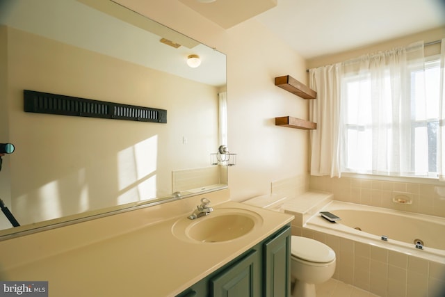 bathroom featuring tile patterned floors, tiled tub, vanity, and toilet