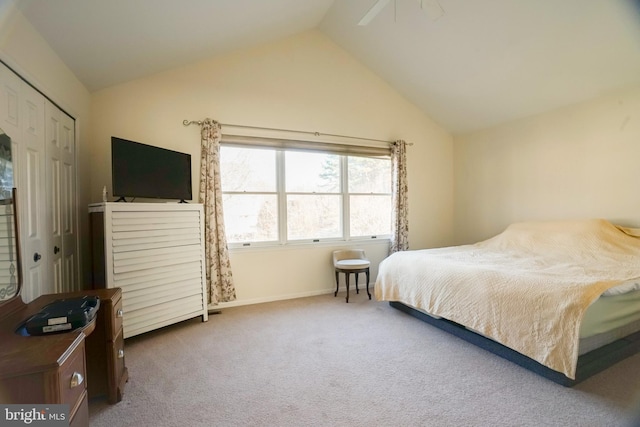 bedroom featuring ceiling fan, a closet, carpet floors, and lofted ceiling