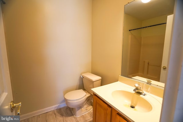 bathroom with a shower, vanity, hardwood / wood-style flooring, and toilet