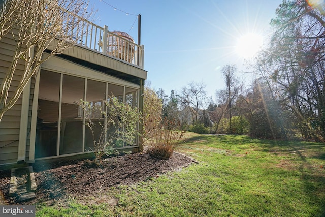 view of yard featuring a sunroom and a balcony