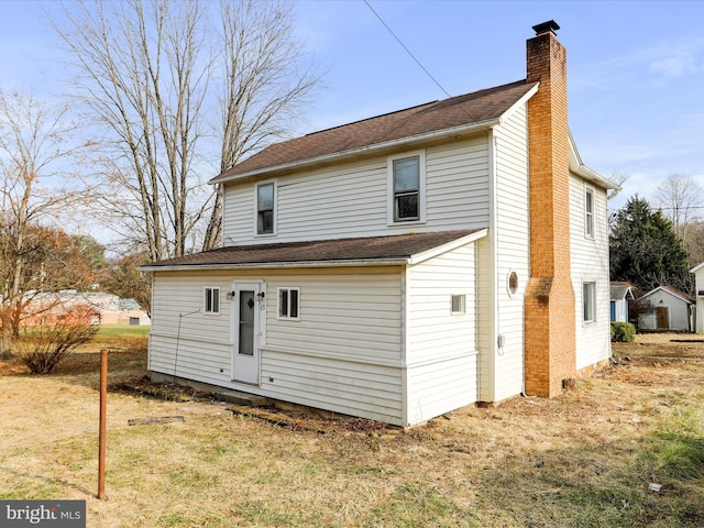 rear view of house featuring a yard