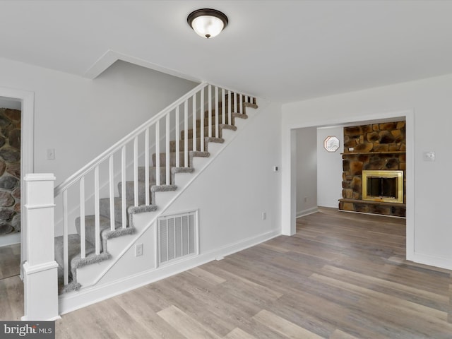 stairway featuring a fireplace and hardwood / wood-style flooring