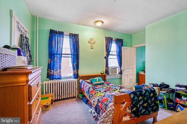 bedroom featuring multiple windows, light carpet, and radiator