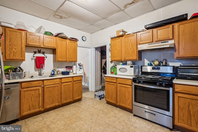 kitchen featuring sink, a drop ceiling, and appliances with stainless steel finishes