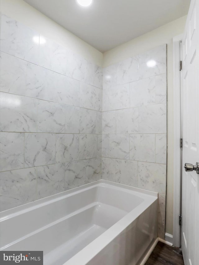 bathroom with a bathing tub and wood-type flooring