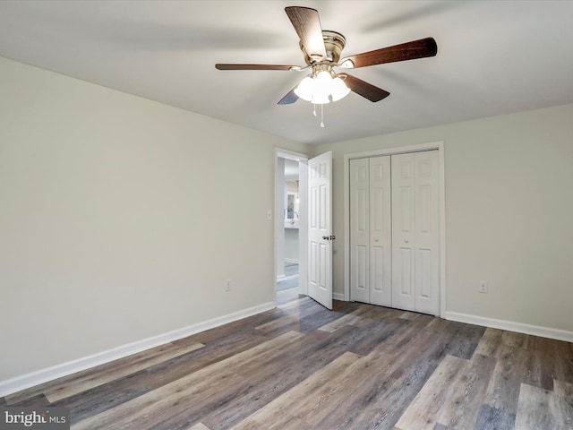 unfurnished bedroom with ceiling fan, wood-type flooring, and a closet