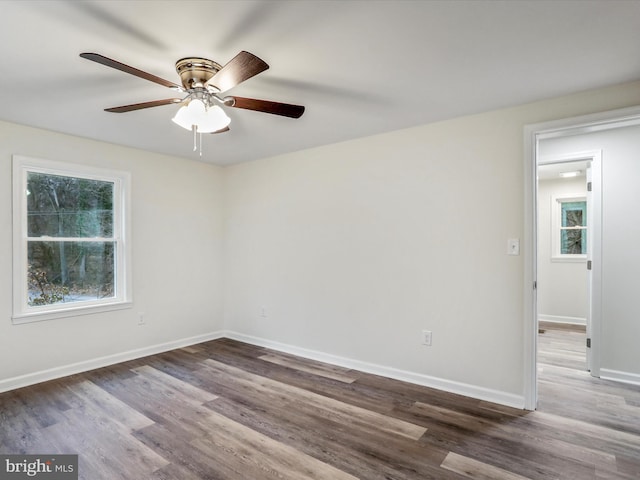 empty room with ceiling fan and dark wood-type flooring