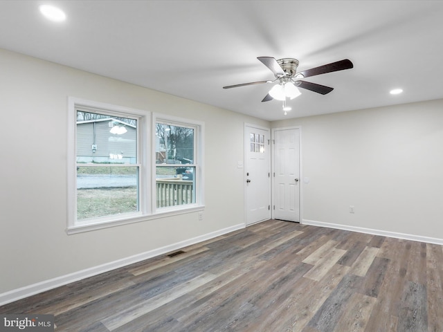 empty room with ceiling fan and dark hardwood / wood-style flooring