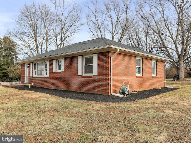 view of side of home with a yard