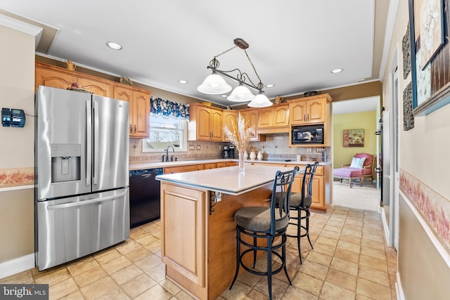 kitchen with decorative backsplash, crown molding, black appliances, decorative light fixtures, and a kitchen island