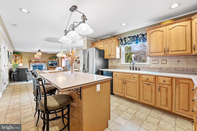 kitchen featuring pendant lighting, a center island, backsplash, stainless steel refrigerator with ice dispenser, and black dishwasher