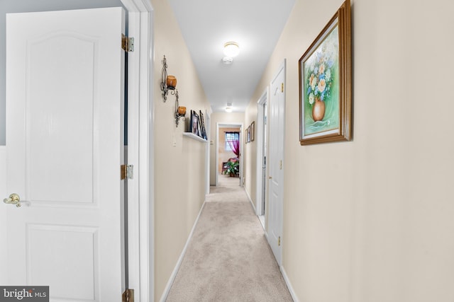 hallway featuring light colored carpet