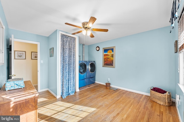 laundry room featuring ceiling fan, washer and dryer, and wood-type flooring