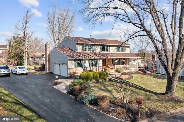 view of front facade featuring a porch, a garage, and a front yard