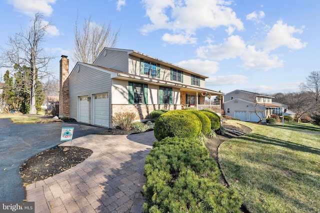 view of front of home with a front yard and a garage