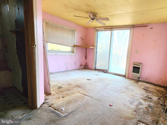 unfurnished room featuring heating unit and ceiling fan