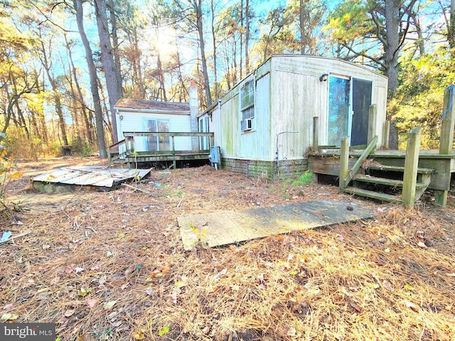 rear view of property featuring a deck and cooling unit