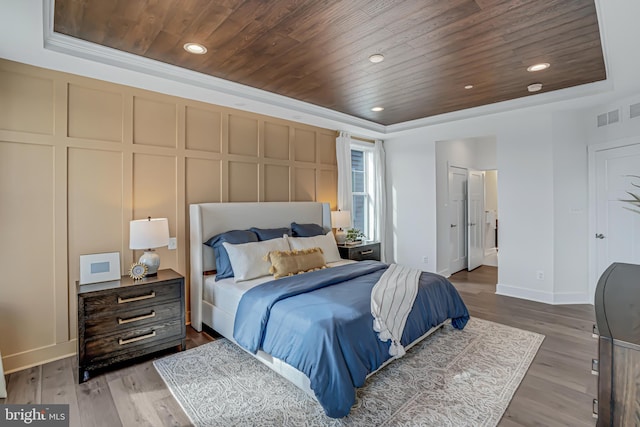 bedroom featuring wood-type flooring, a tray ceiling, and wood ceiling