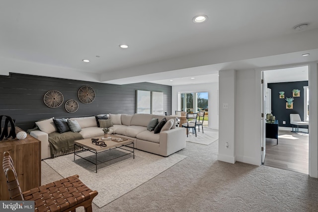 living room with wood walls and light carpet