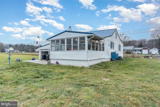 view of home's exterior featuring a sunroom and a yard