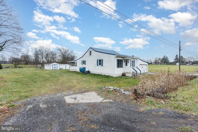 view of home's exterior with a yard, an outdoor structure, a garage, and a storage unit