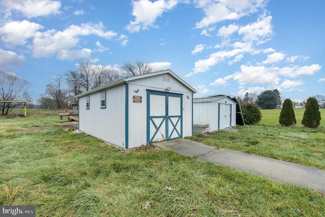 view of outdoor structure with a lawn and a rural view